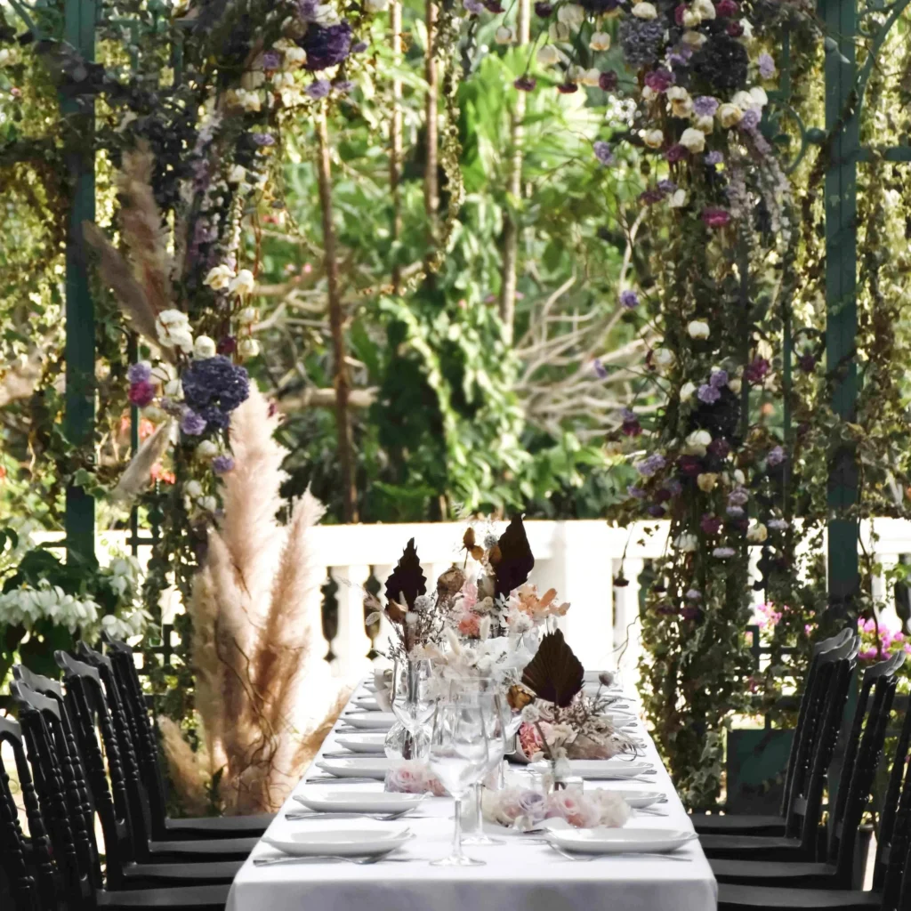 Conservatory dining table surrounded by greenery at UNA, The Alkaff Mansion
